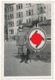 Soldier in front of swastika flag
