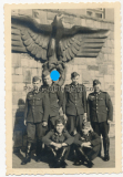 Soldaten der Wehrmacht vor einem großen Reichsadler mit Hakenkreuz